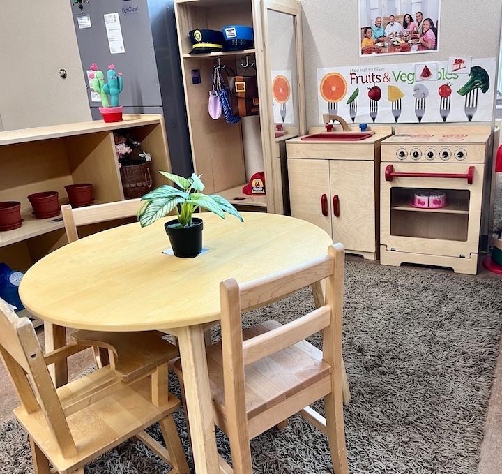 transitional kindergarten classroom with child-size table, play kitchen