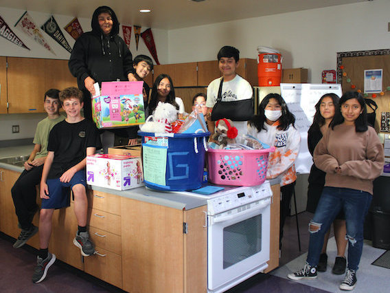 group of students around counter with donations of food