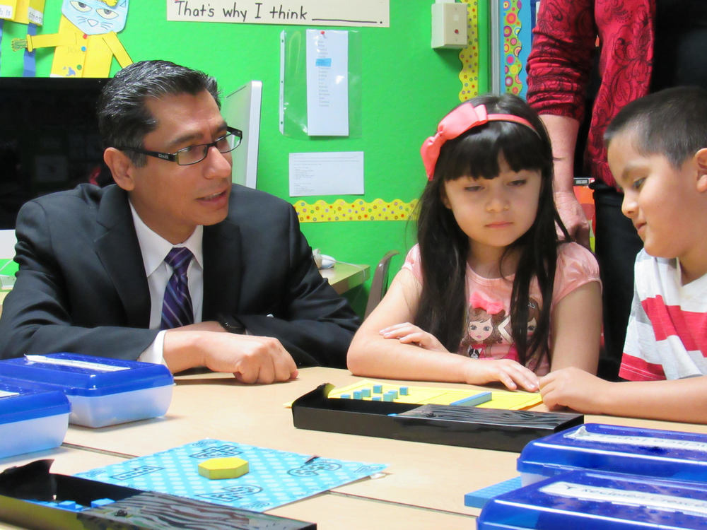 Dr. Ibarra working with two third grade students.