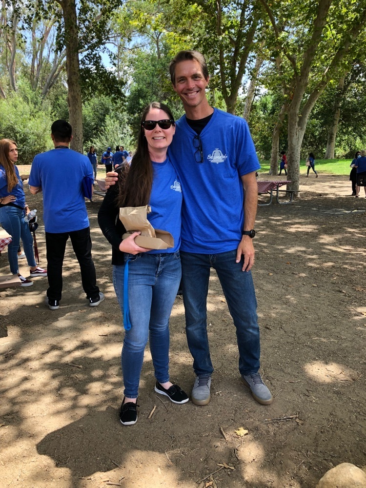 man and woman in blue shirts standing in park