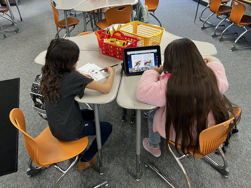 two girls working at table in classroom