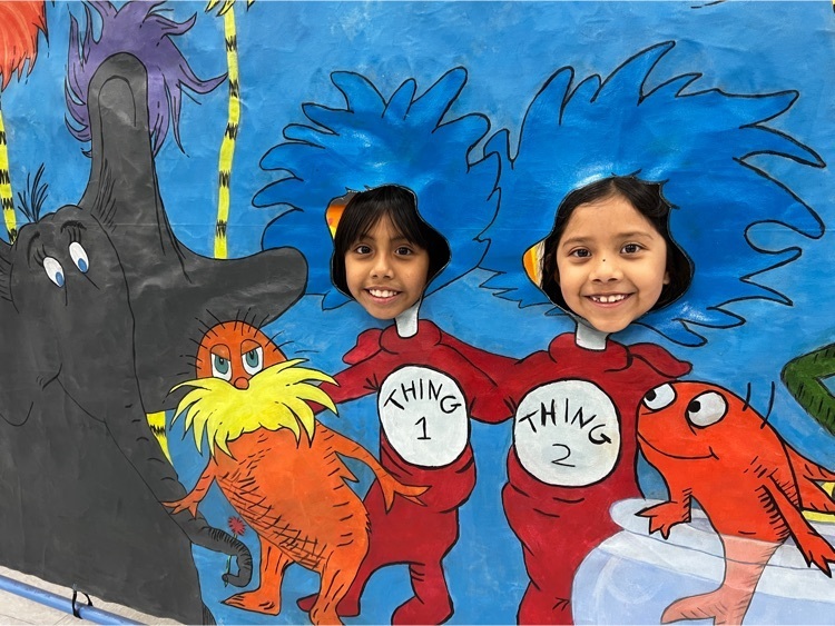 two girls’ faces in cutout of Dr Seuss prop