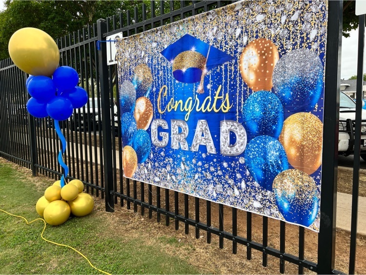 Congrats Grad sign on fence with blue and gold balloons