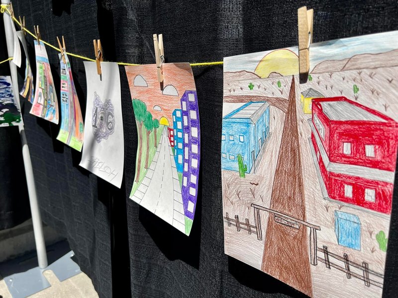student drawings of roads hanging on clothesline display