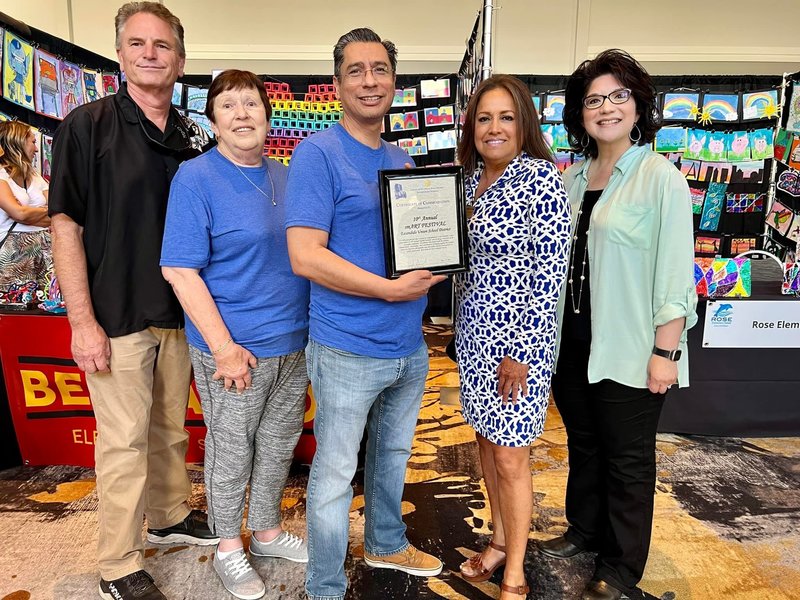 escondido staff holding framed certificate at art show