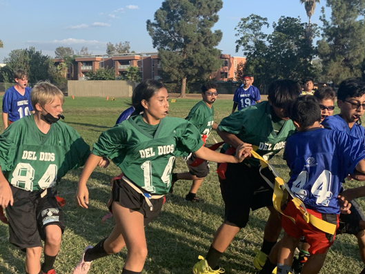 girls and boys on field playing flag football