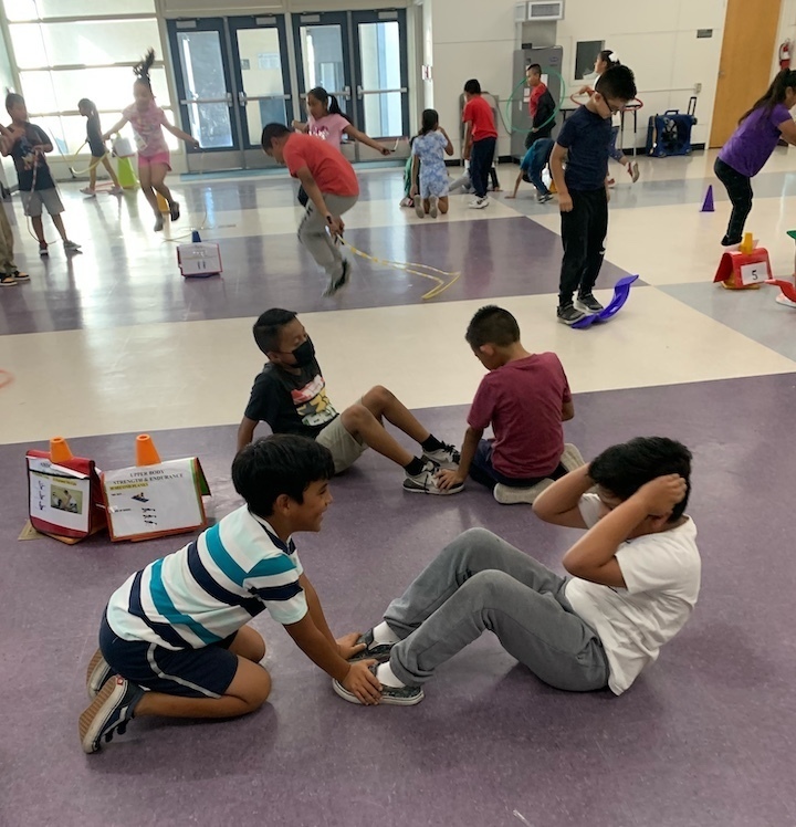 two boys doing sit-ups in multipurpose room